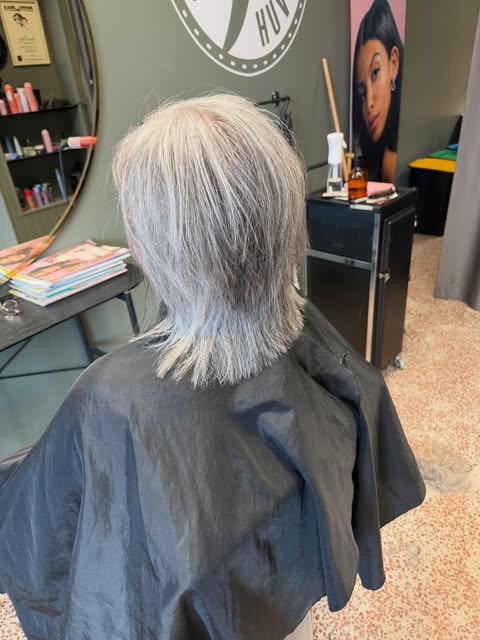 Kall blond klippning med logo i bakgrunden
